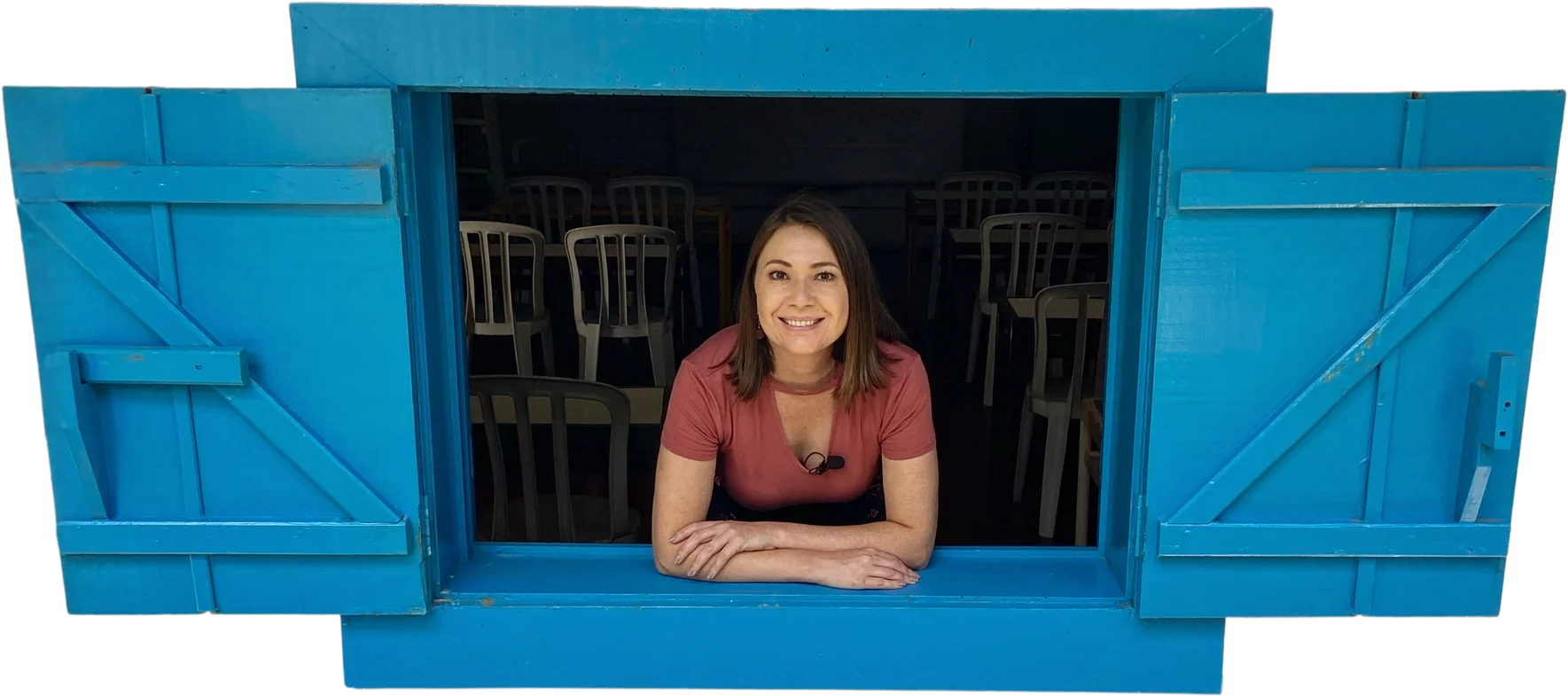 Elaine debruçada em uma janela azul de madeira