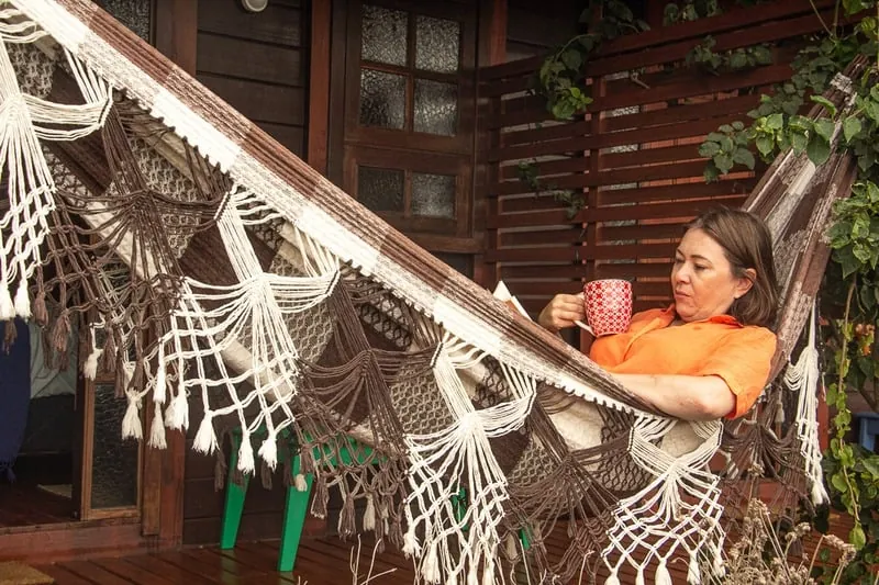 Elaine em uma rede, segurando uma caneca